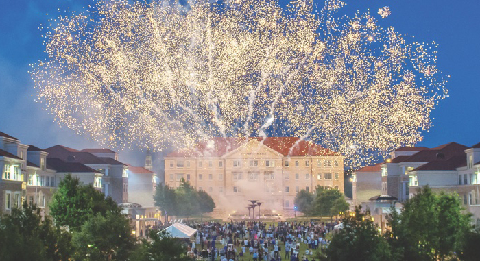 Fireworks exploding above a crowd gathered in the Campus Commons