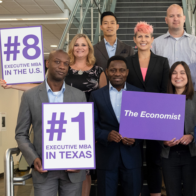 Group of EMBA students with signs