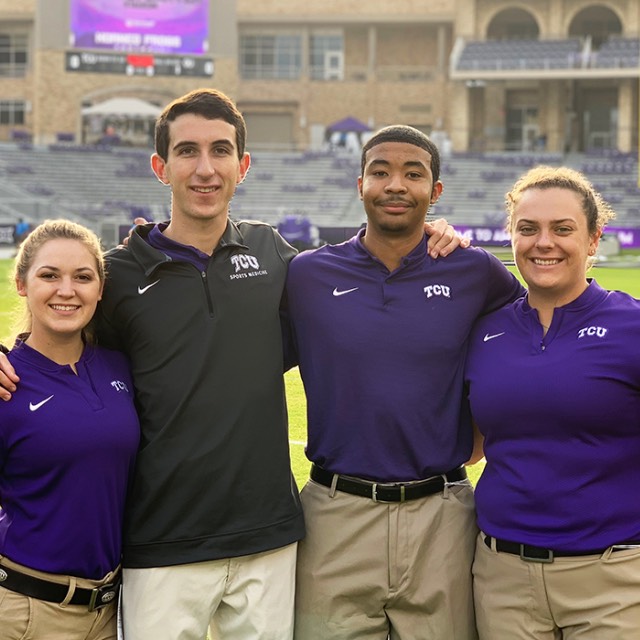 A group of athletic training students standing on the football field