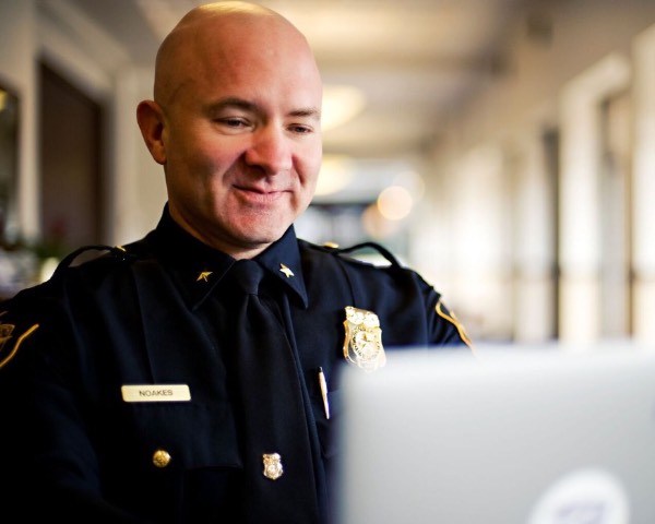 A TCU police officer works on a laptop computer