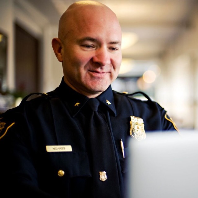 A TCU police officer works on a laptop computer
