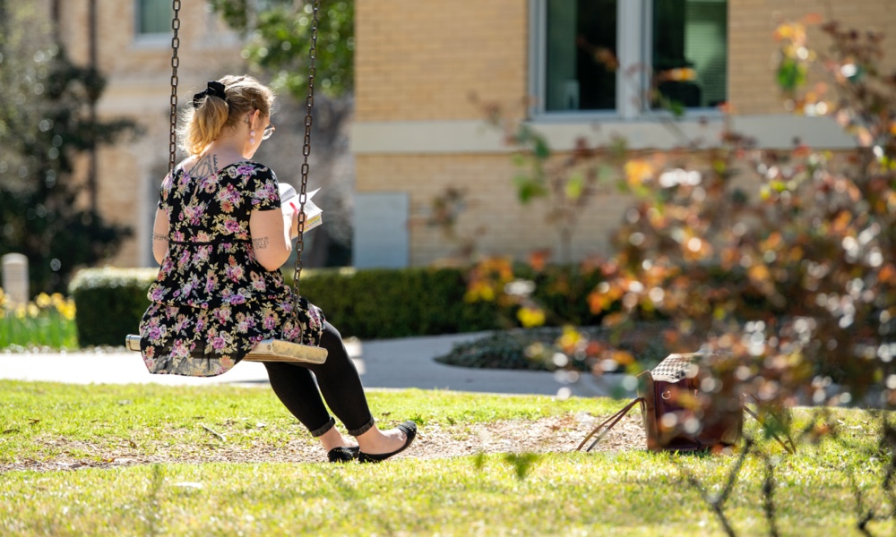 female student in swing on campus