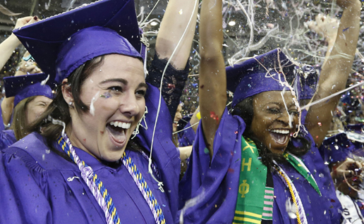 TCU graduates in caps and gowns set off handheld confetti cannons spewing multi-colored confetti into the air