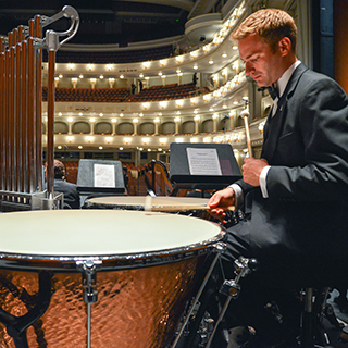 A male TCU music student in a tuxedo rehearses percussion at Fort Worth's Bass Performance Hall