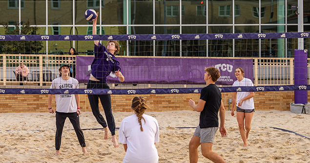 Students playing sand volleyball