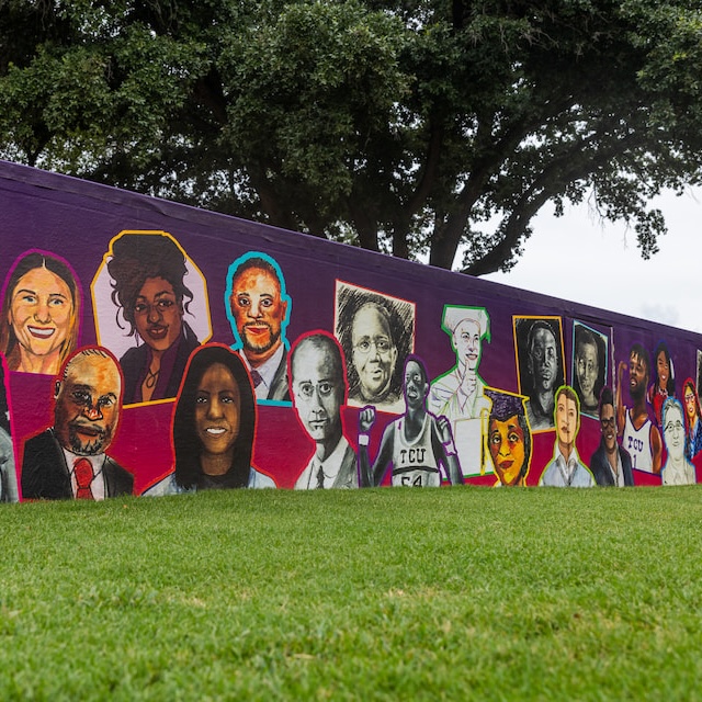 A colorful mural featuring portaits of individuals' faces