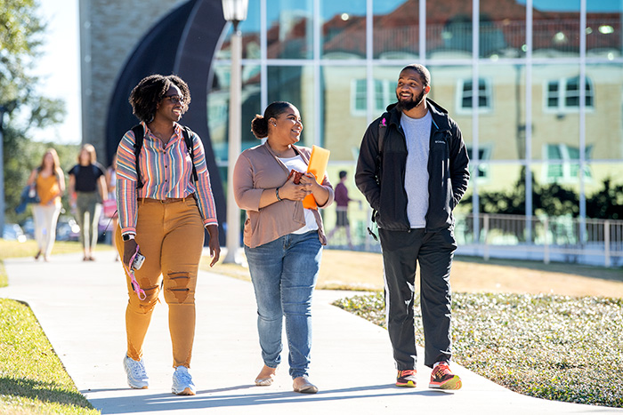 Three TCU students walk together on campus